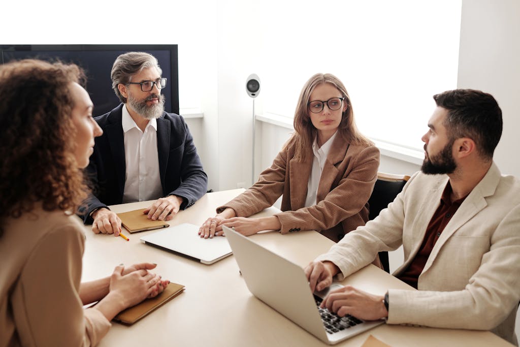 Ireland Budget 2026 Business Guide Infographic Business colleagues engaged in a serious discussion around a conference table.