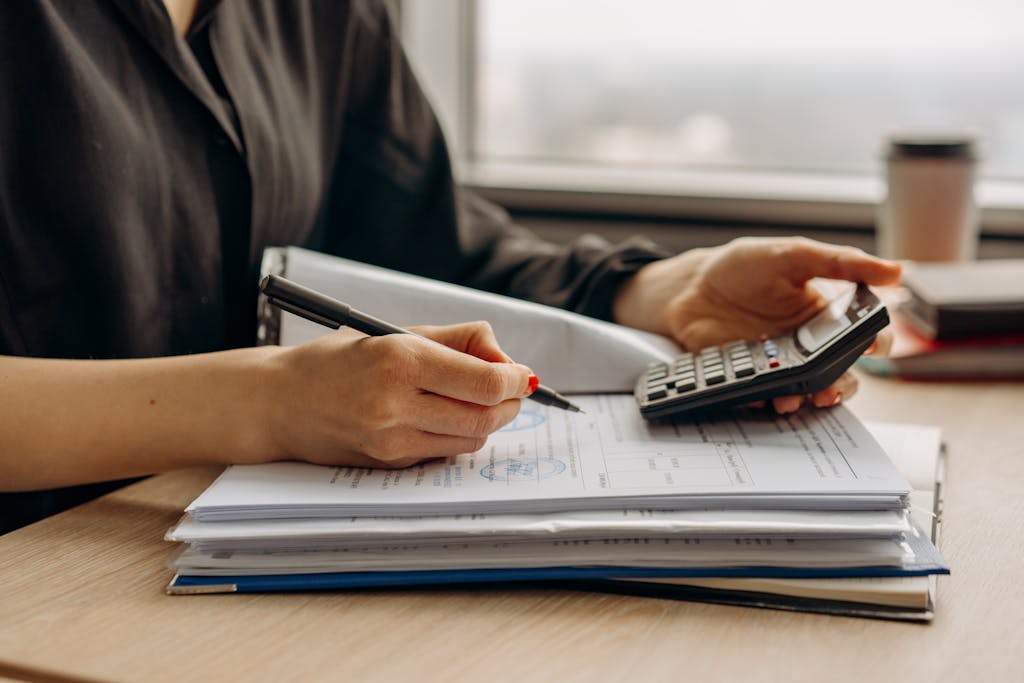 Person in Long Sleeve Shirt Holding a Calculator and doing Management Accounting